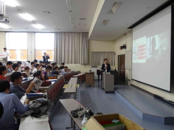 企業のプレゼンテーションを聞く学生